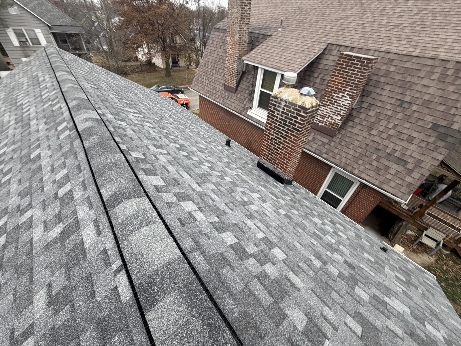 Ridge line detail on a shingle roof inspected slope by slope