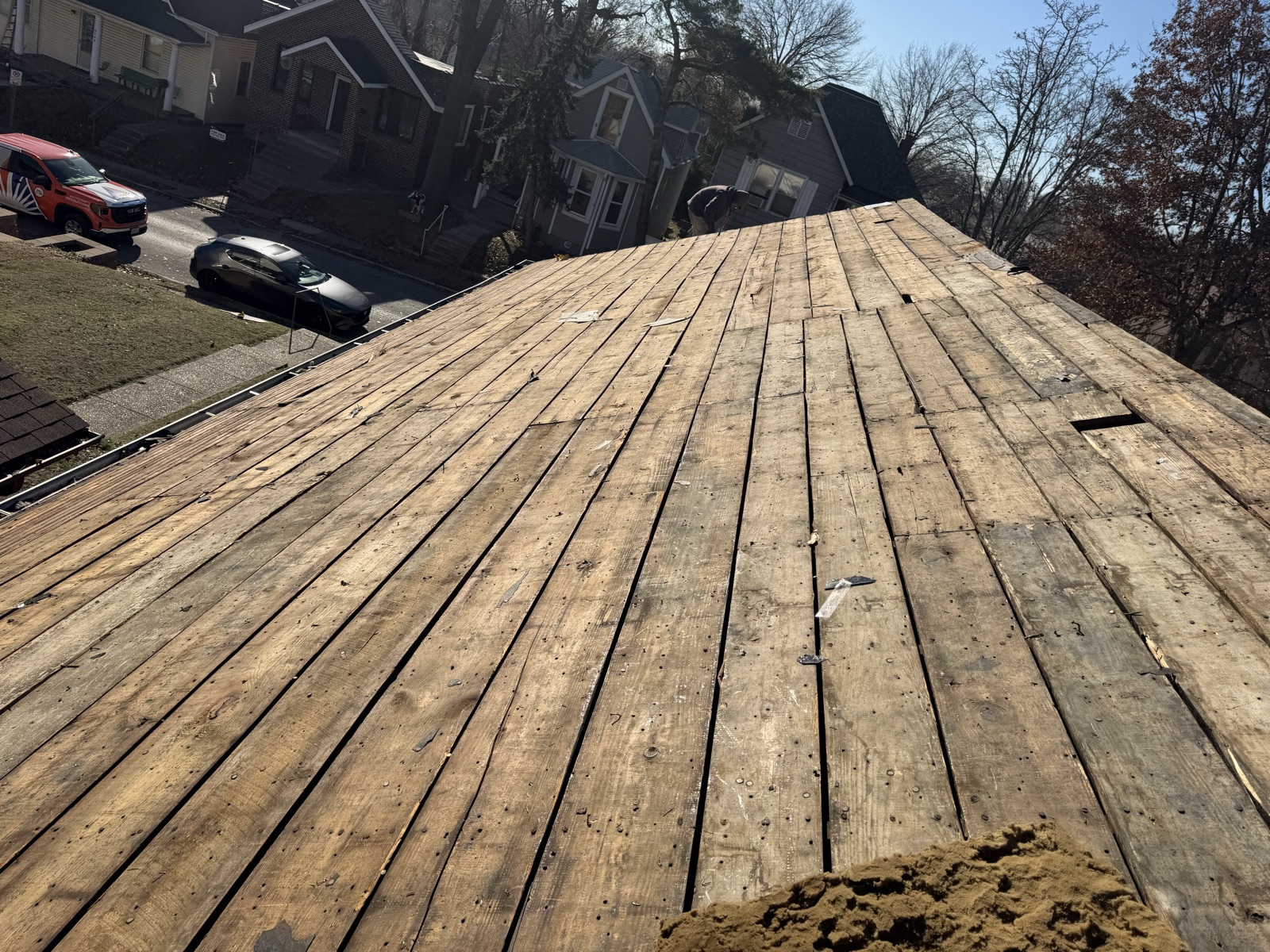 Roofing crew mid tear-off on a residential roof