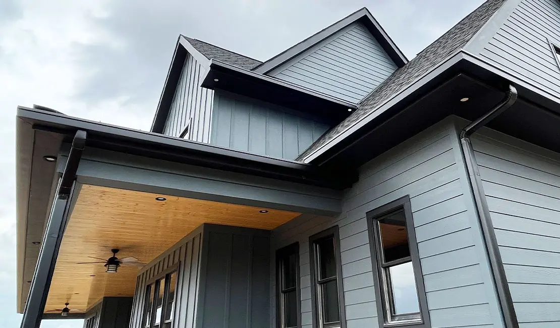 Modern aluminum downspouts routing water down an exterior wall